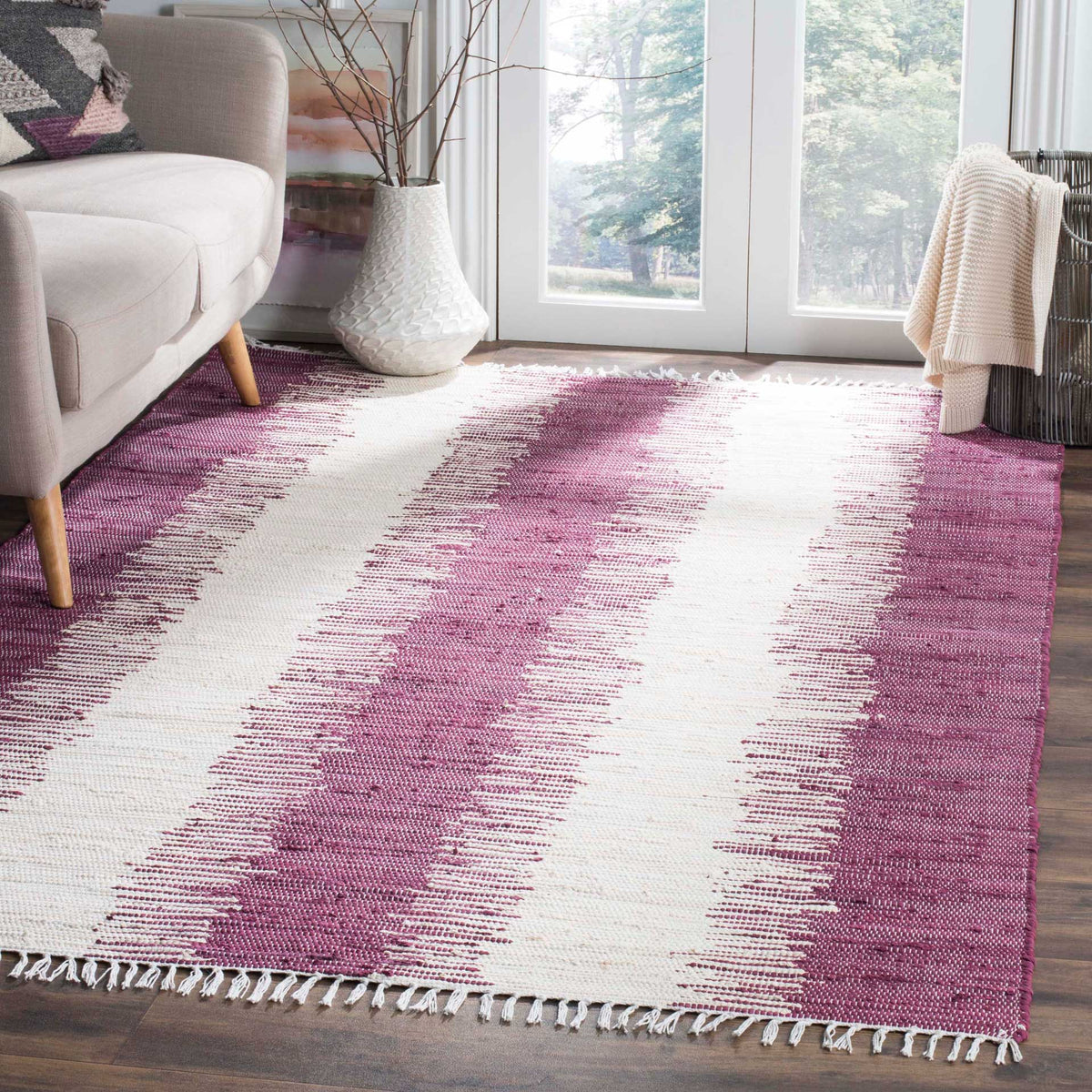 Plum-purple stripes and ivory bands anchor the space with bold color and fringed texture.