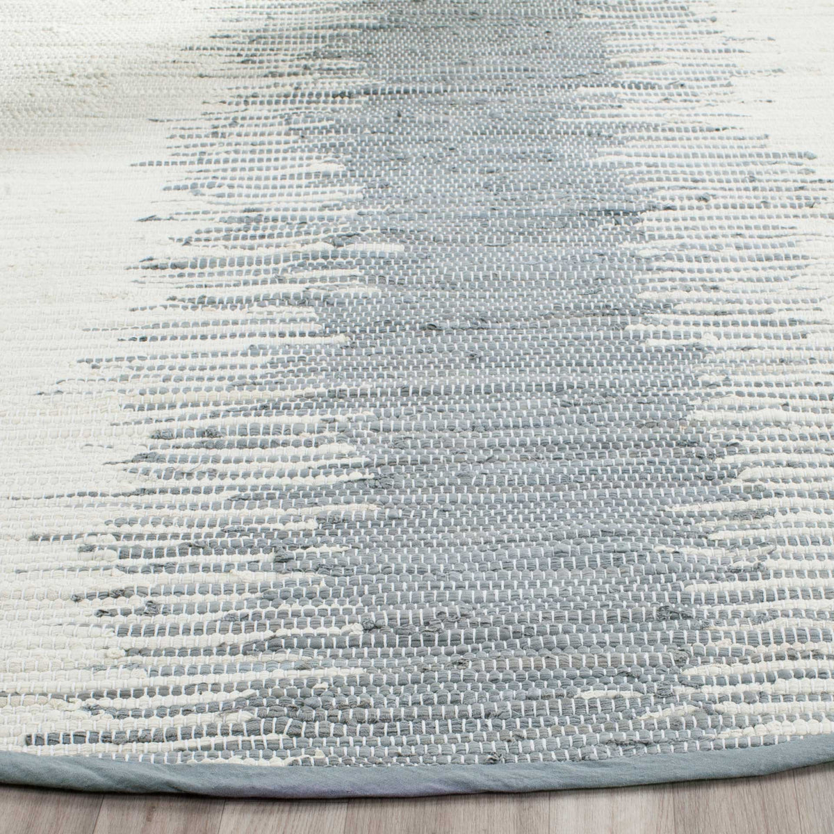 Variegated gray and ivory cotton weave shows tactile texture and a neatly bound edge