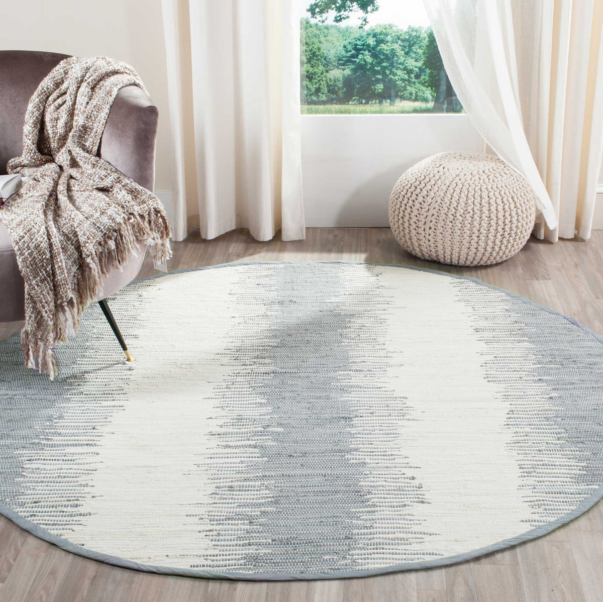 Soft gray and ivory bands bring understated pattern to this round woven rug