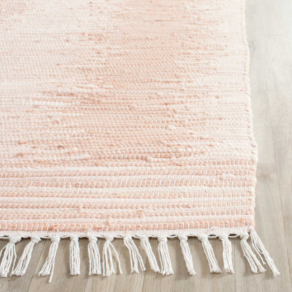 Soft beige and ivory yarns create a tactile weave with long, airy fringe