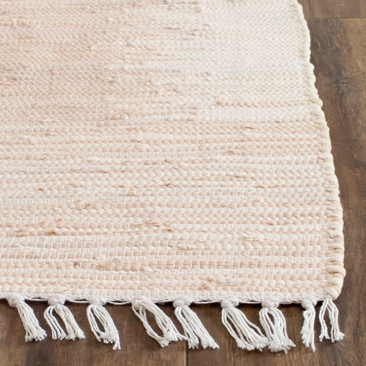 Textured beige cotton weave meets a neatly finished edge and loose ivory fringe