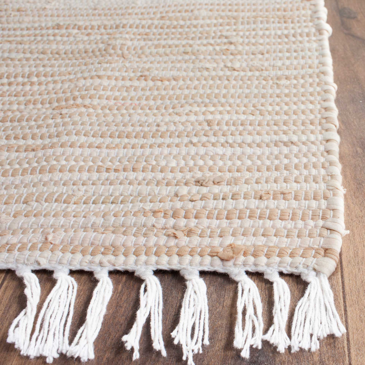 Textured beige and ivory cotton weave meets a finished edge with loose white fringe