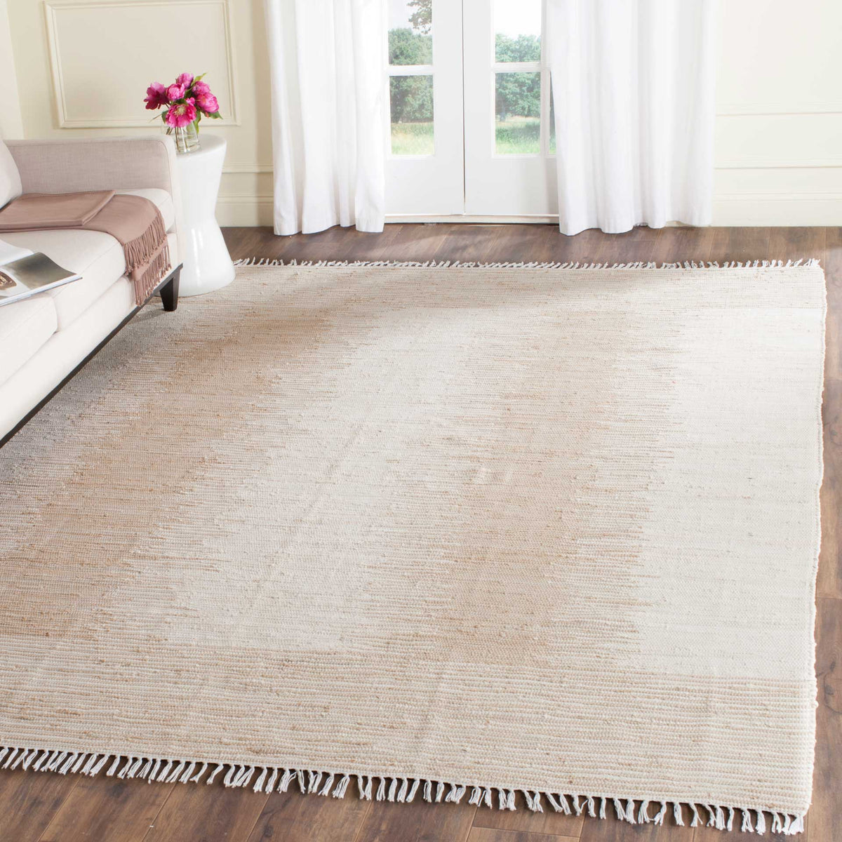 Fringed beige and ivory rug adds warm, understated texture to a bright living space