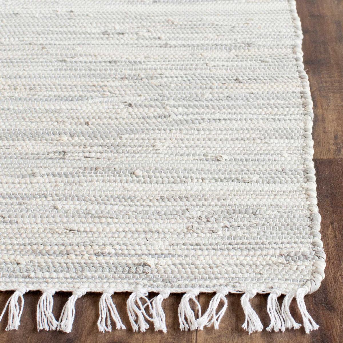 Textured cotton weave and delicate fringe lend artisan detail to the silver rug