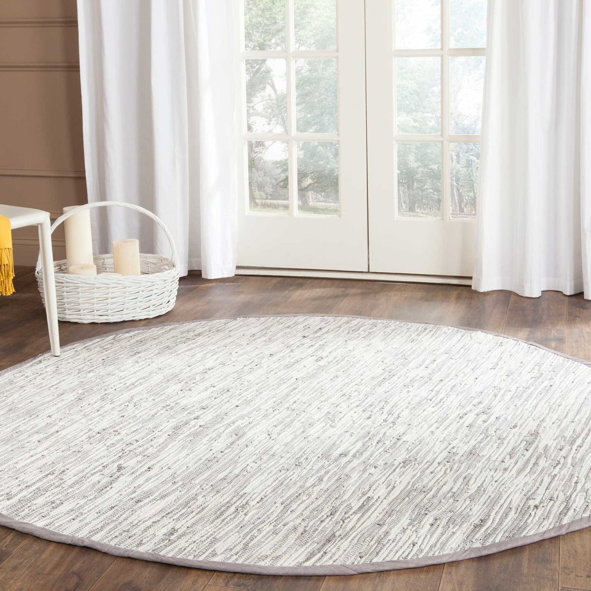 Round silver-and-white rug adds a softly textured accent to warm wood floors