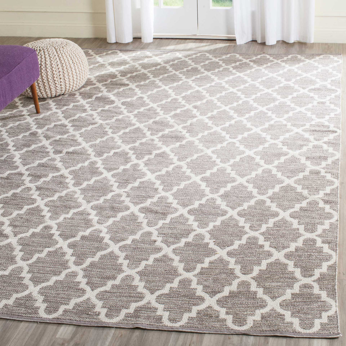 An expansive gray and ivory quatrefoil rug brings soothing pattern to a light-filled living space.