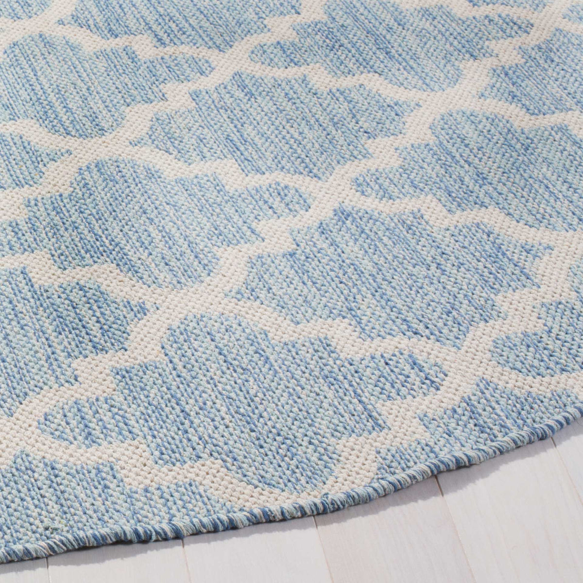 Woven light blue and ivory cotton brings soft texture to a neatly bound curved edge