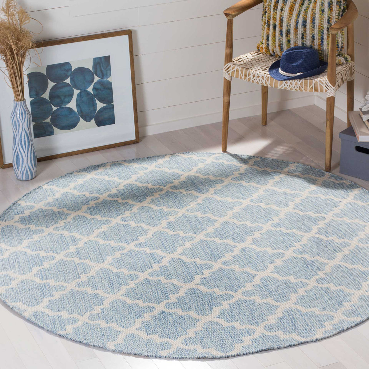 Round light blue-and-ivory rug adds soft color and a delicate trellis pattern to the room