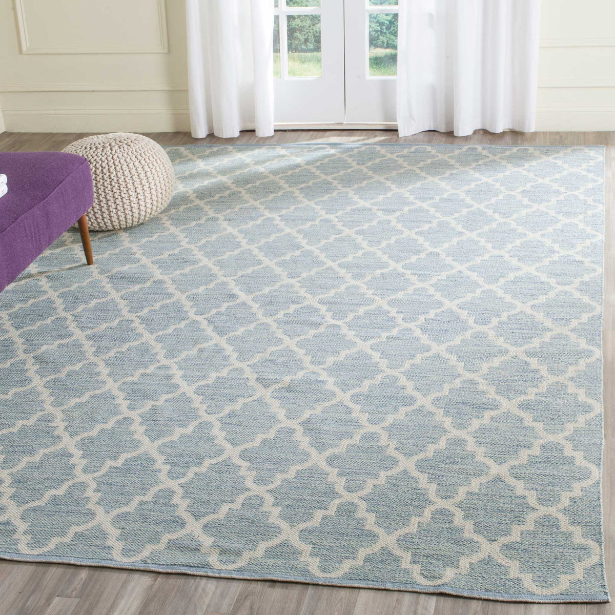 An airy light blue and ivory trellis rug gives the sitting area a serene, inviting foundation.