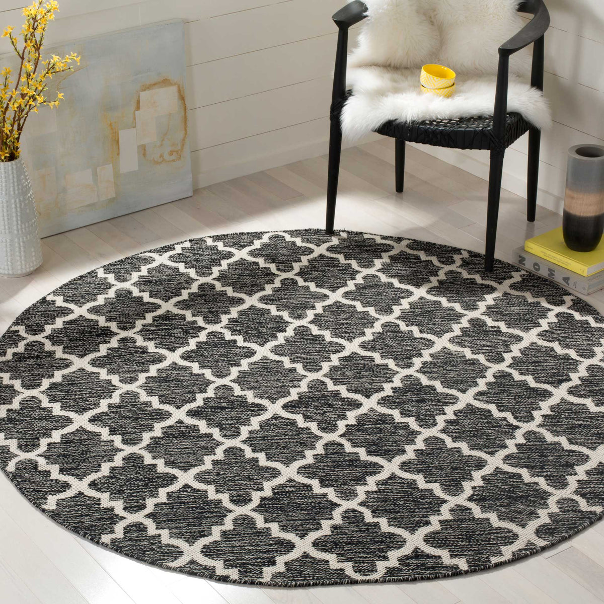 Black-and-ivory trellis rug brings crisp geometric contrast to a bright sitting space