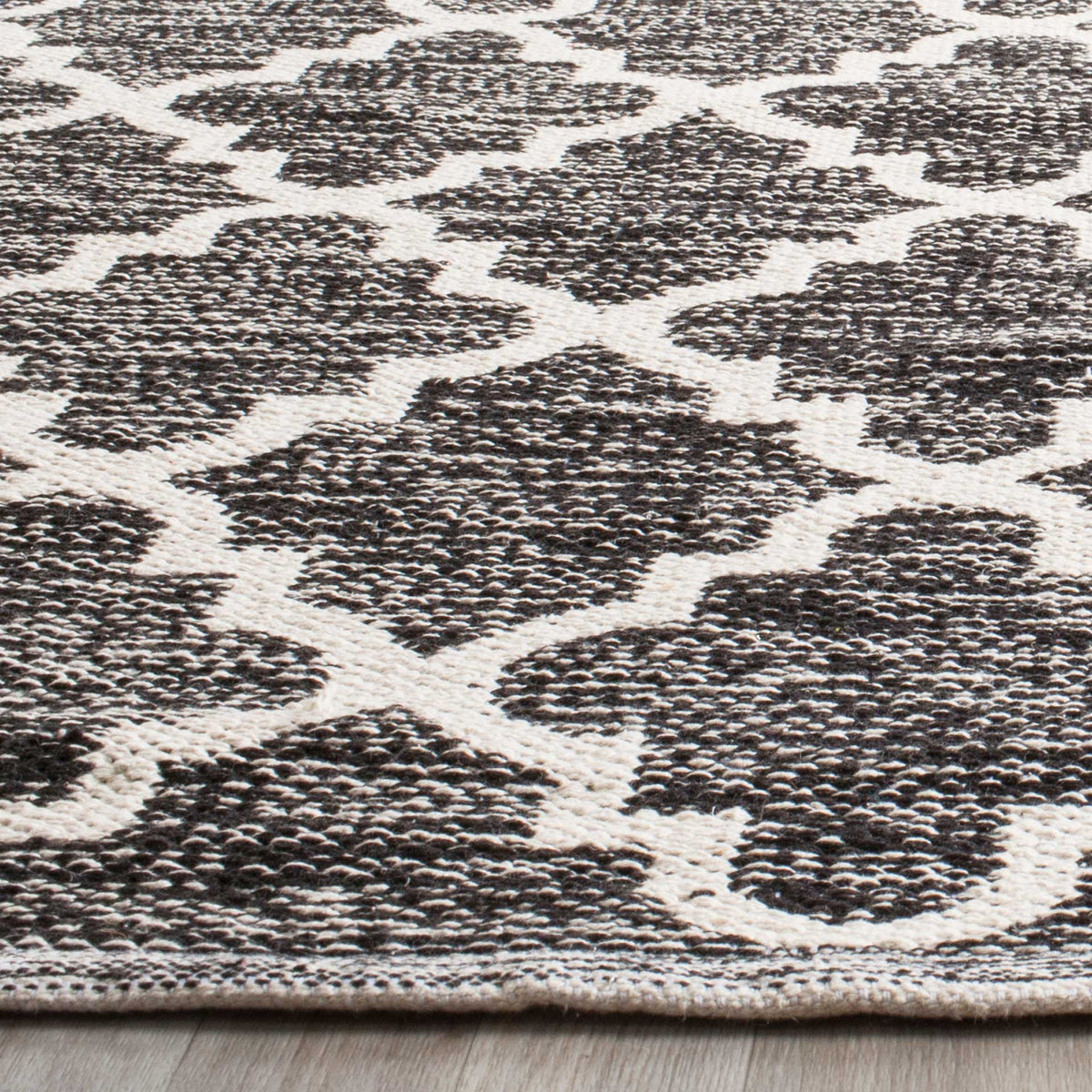 Dense black cotton yarns meet bright ivory outlines in a richly textured geometric weave.