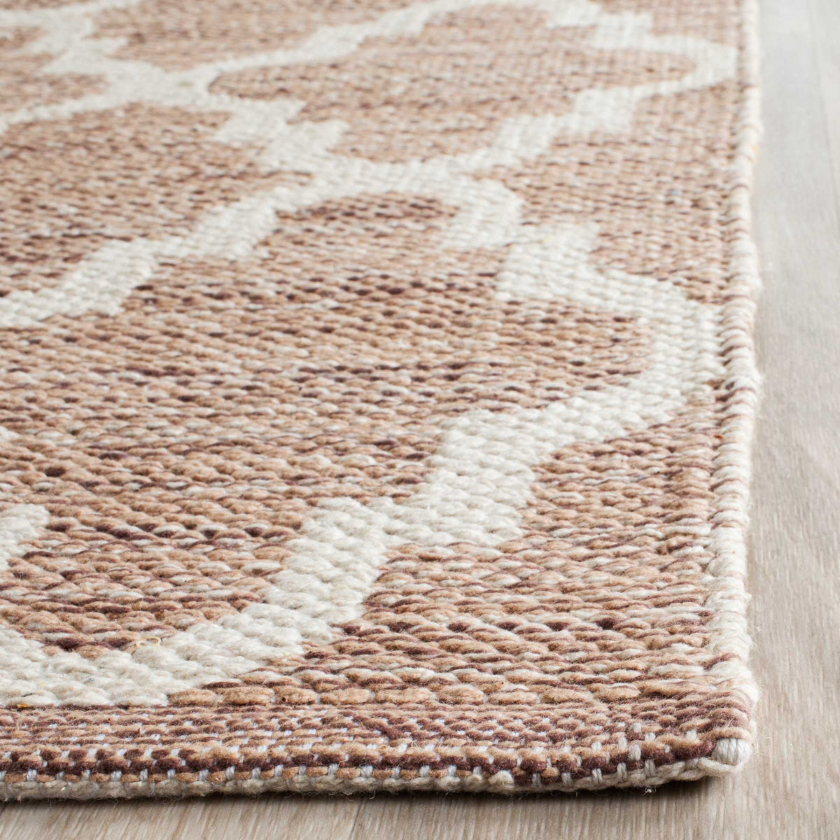 Textured cotton yarns form an ivory trellis and a neatly finished edge on this beige runner.