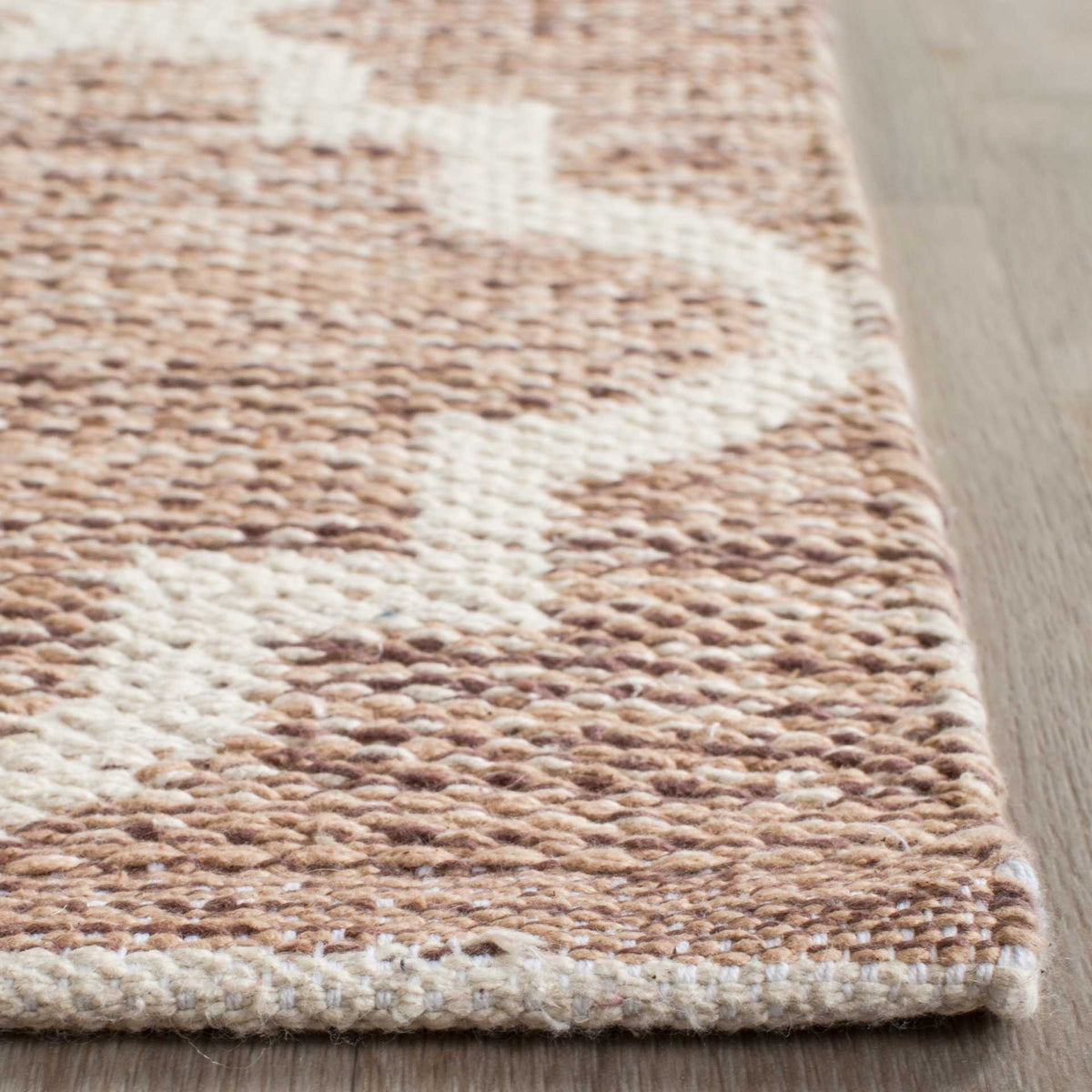 A tidy woven border frames the beige yarns and ivory quatrefoil curves.