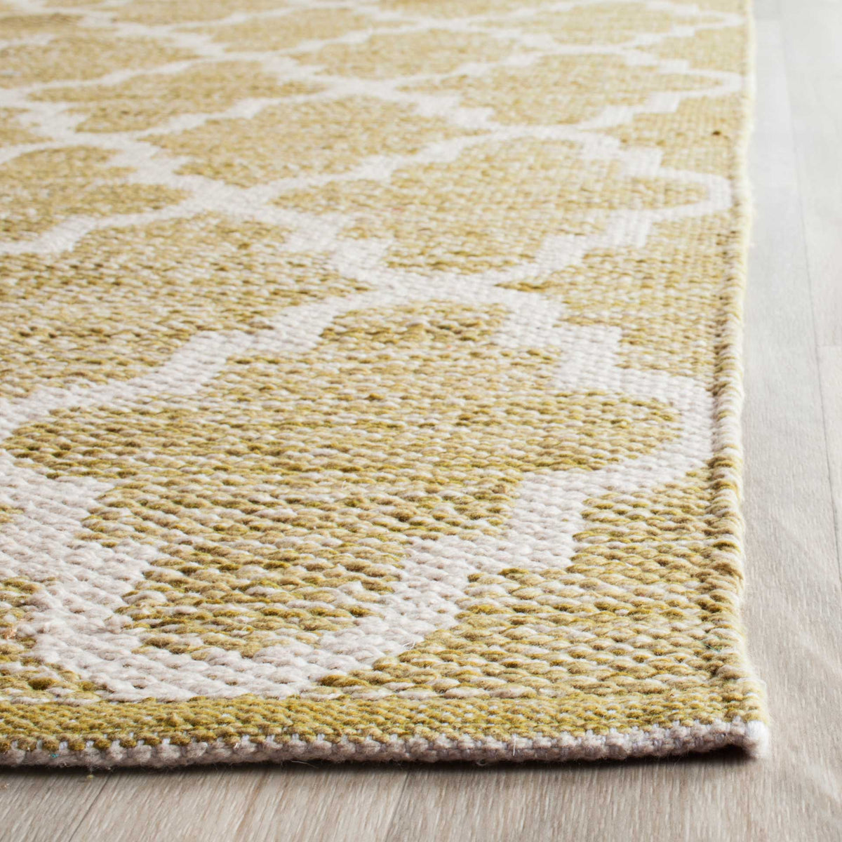 Golden olive cotton fibers meet ivory lines in a textured weave with a neatly finished corner.