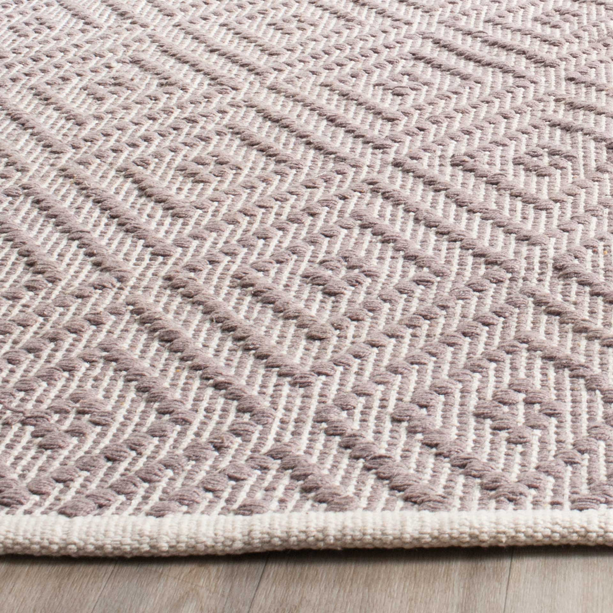 Gray woven loops form nested diamonds above a clean ivory edge.