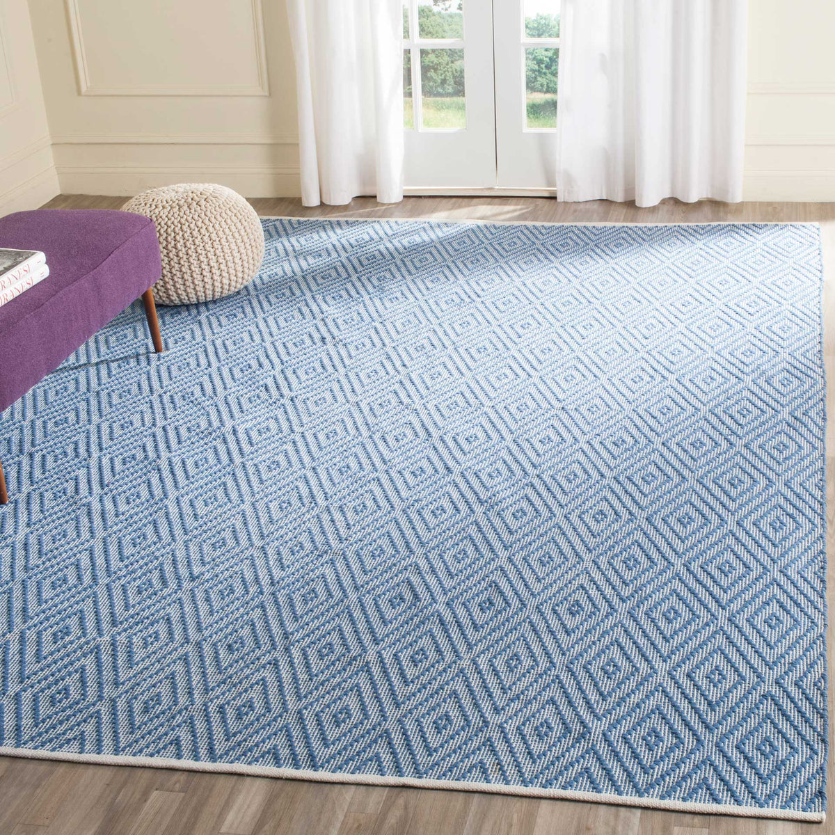 A spacious blue and ivory diamond rug adds fresh pattern to a living area.