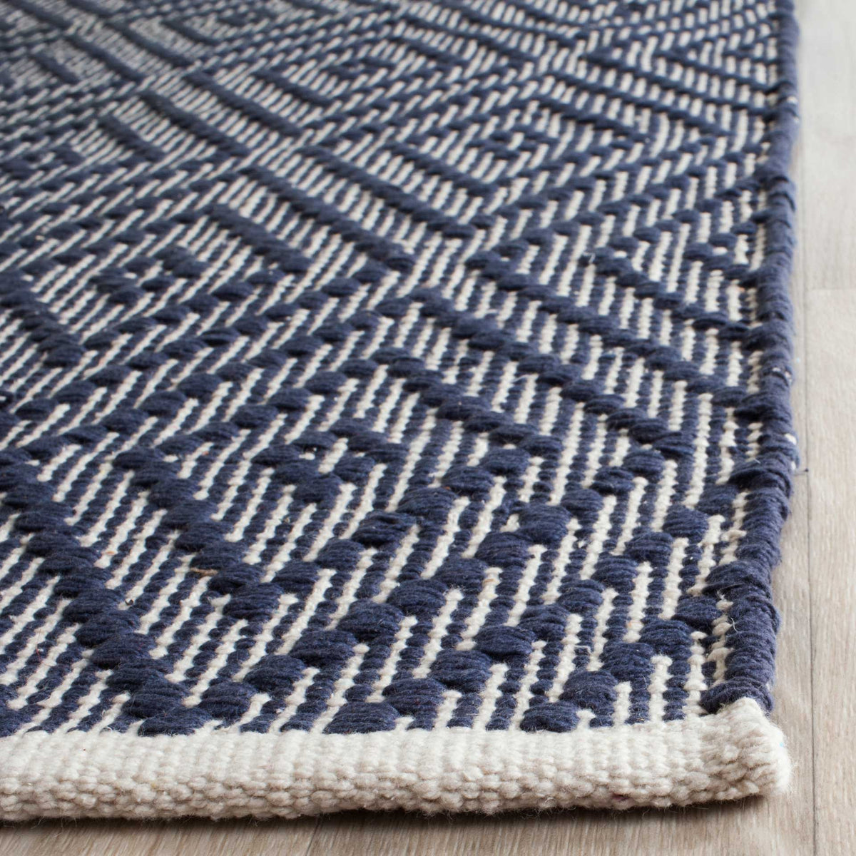 Raised navy cotton threads create tactile diamonds above a neatly woven ivory edge.