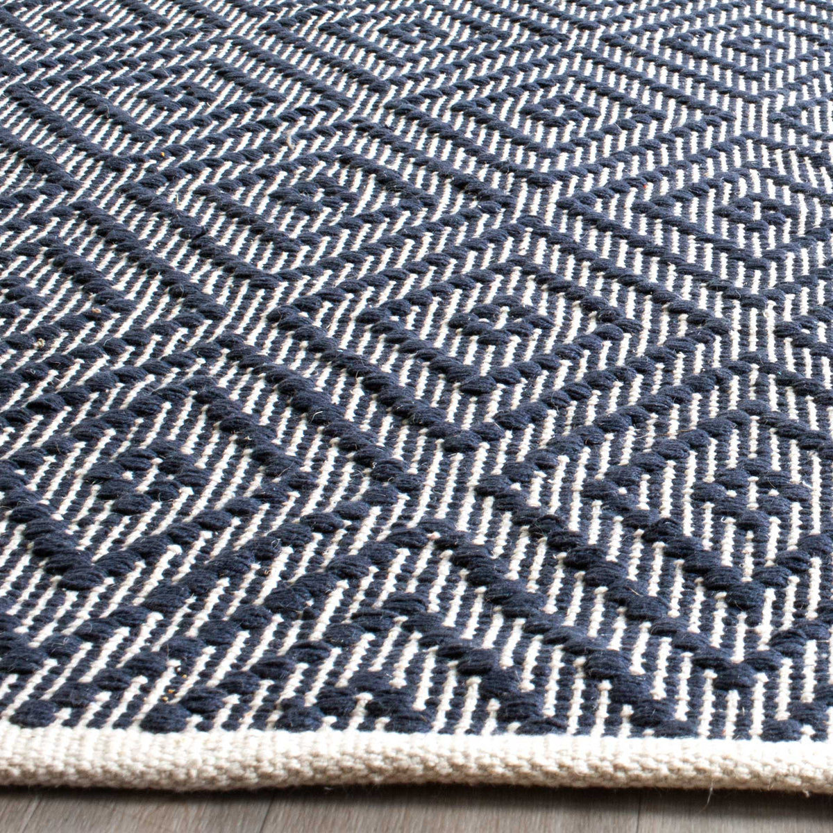 Textured navy cotton diamonds stand out over ivory stripes along a bound edge.