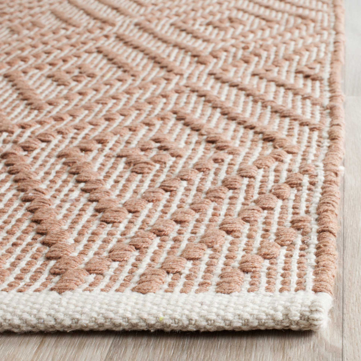 Raised beige cotton threads meet a neatly woven ivory edge for rich texture underfoot.