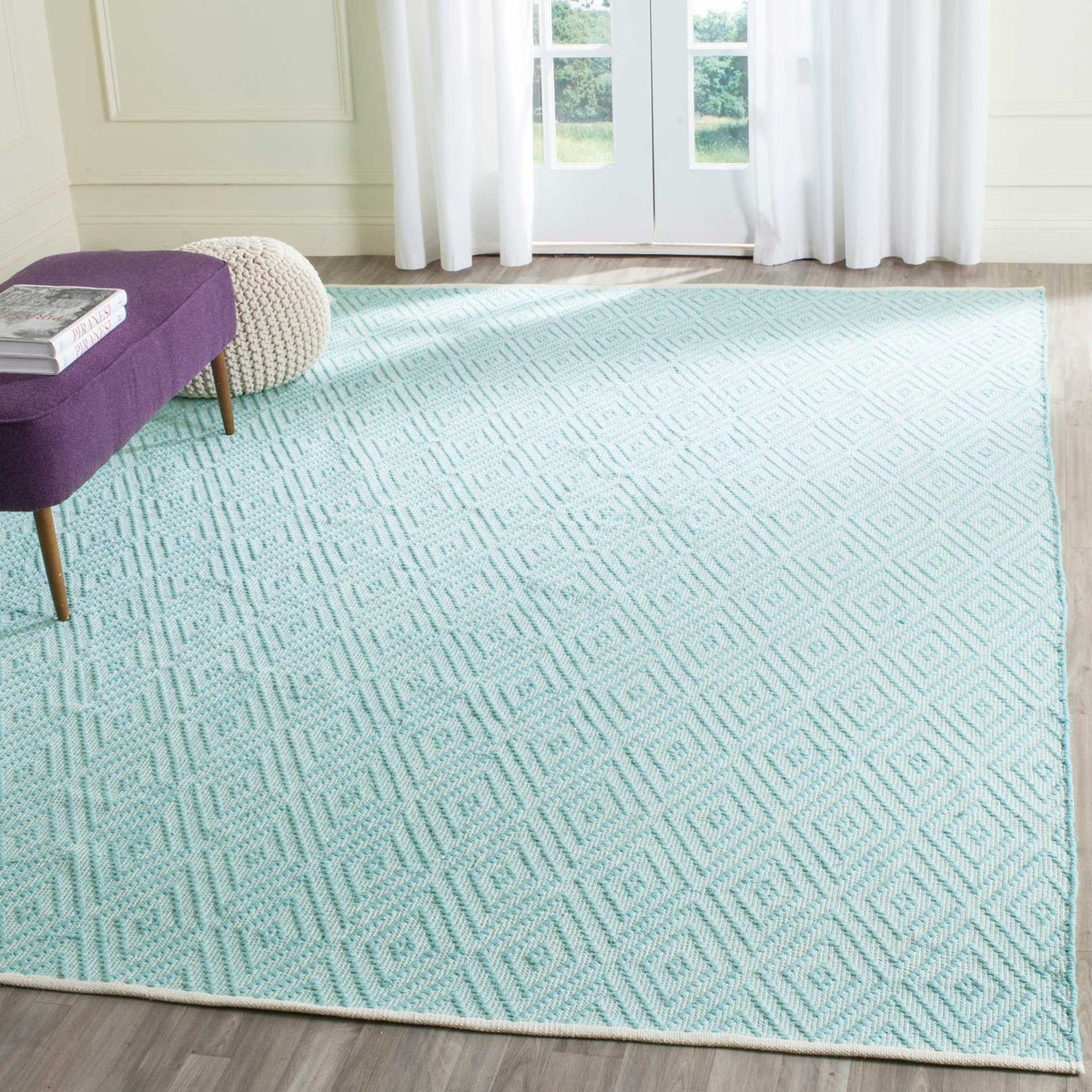 A roomy turquoise and ivory diamond rug brings an airy, colorful foundation to the space.
