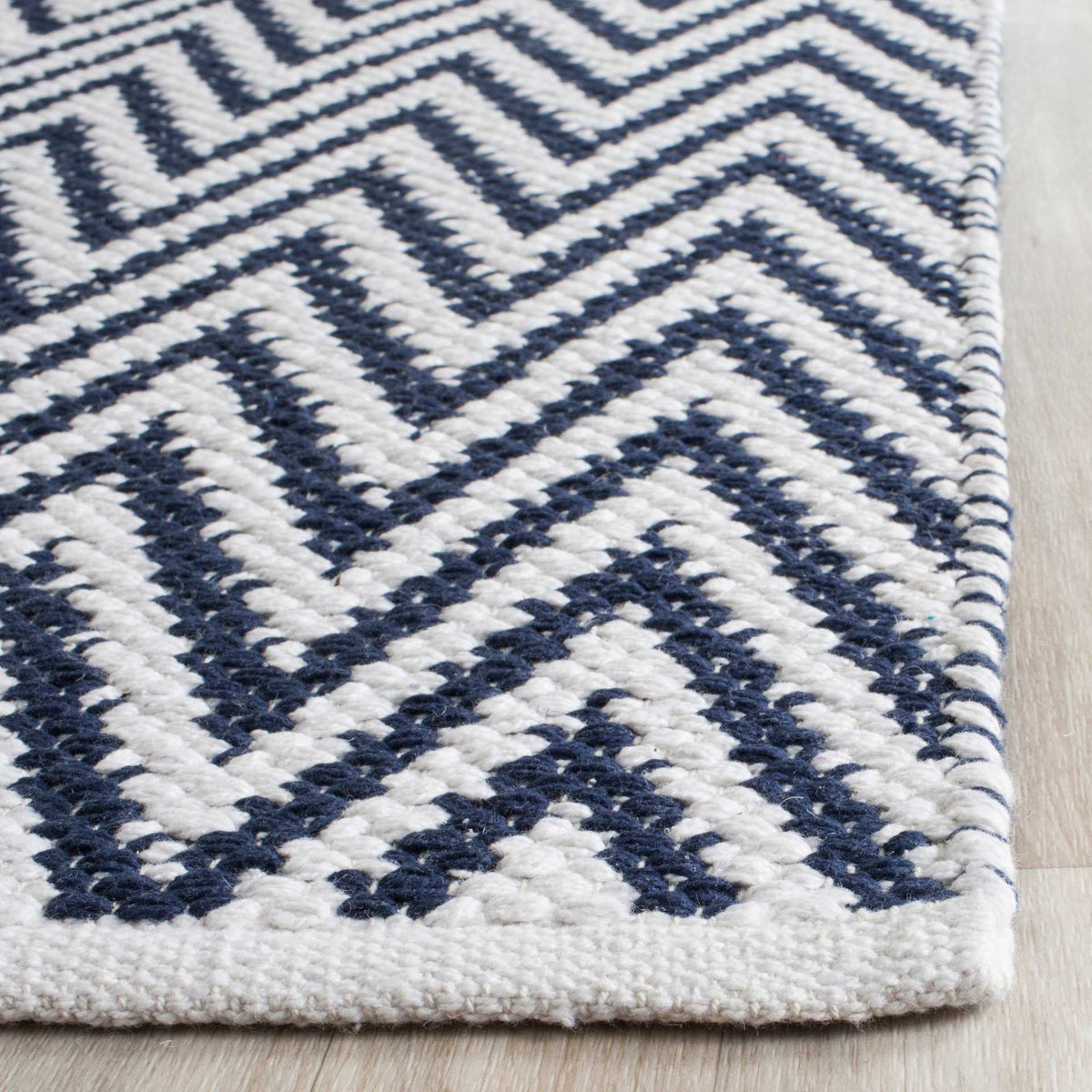 Textured navy and ivory cotton chevrons end in a clean ivory woven border.