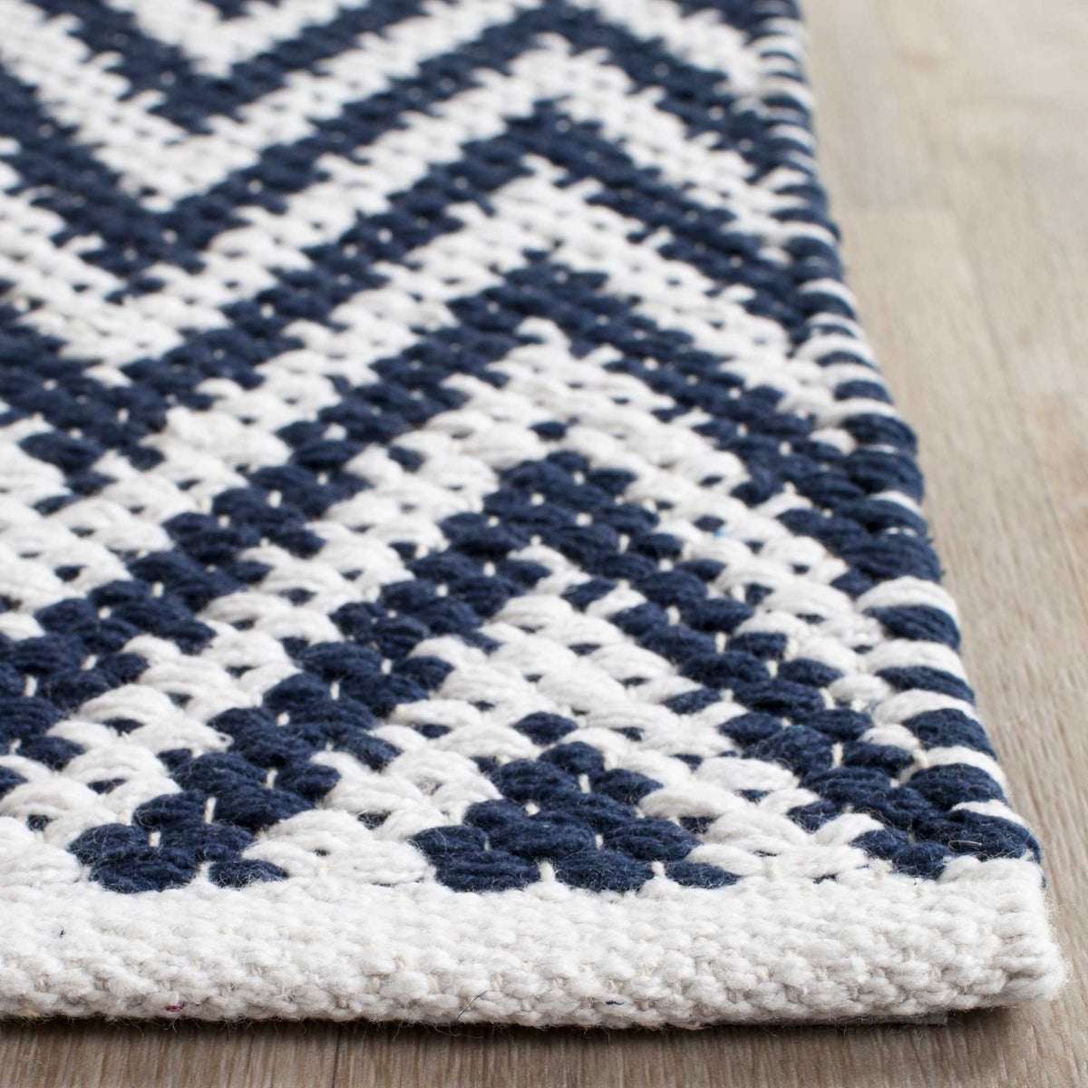 Chunky navy and ivory cotton stitches meet at a thick, bound corner.
