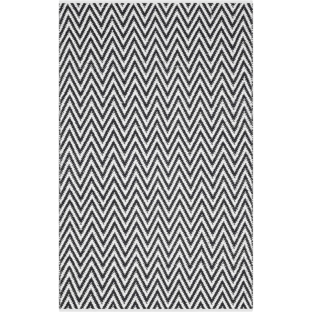 Bold black chevrons cross ivory on a smaller rectangular cotton rug.