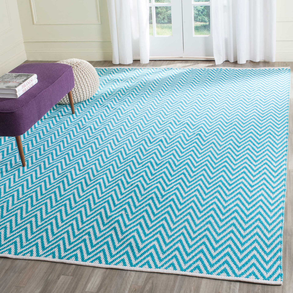 A field of turquoise and ivory chevrons creates a vibrant, airy floor accent.