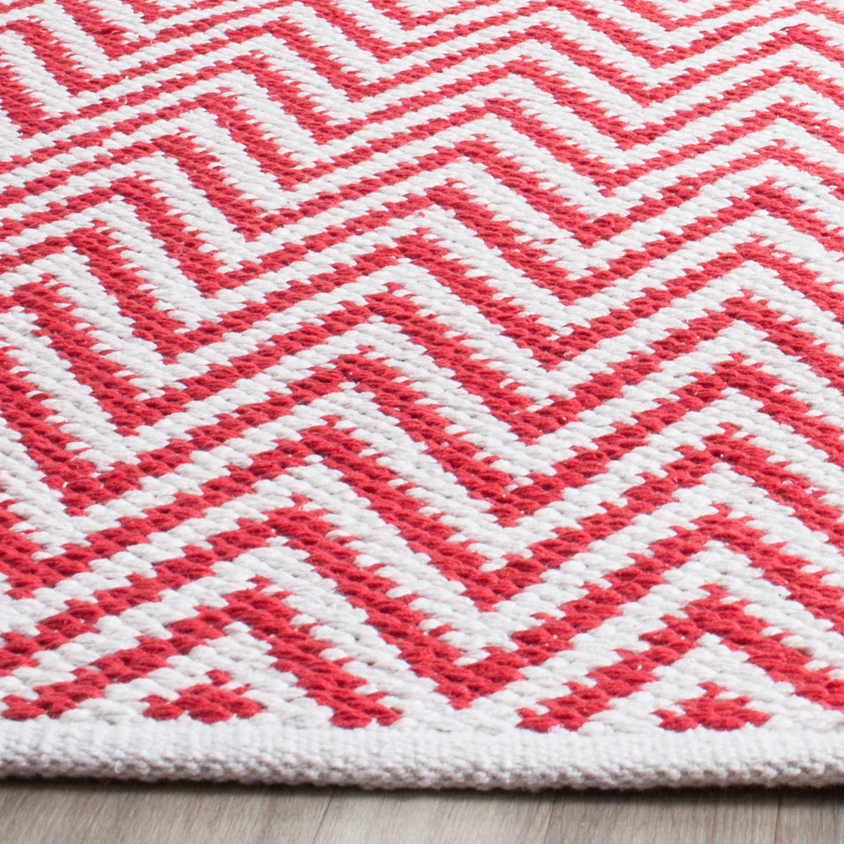 Bright red cotton chevrons stand out against ivory above a tidy woven edge.