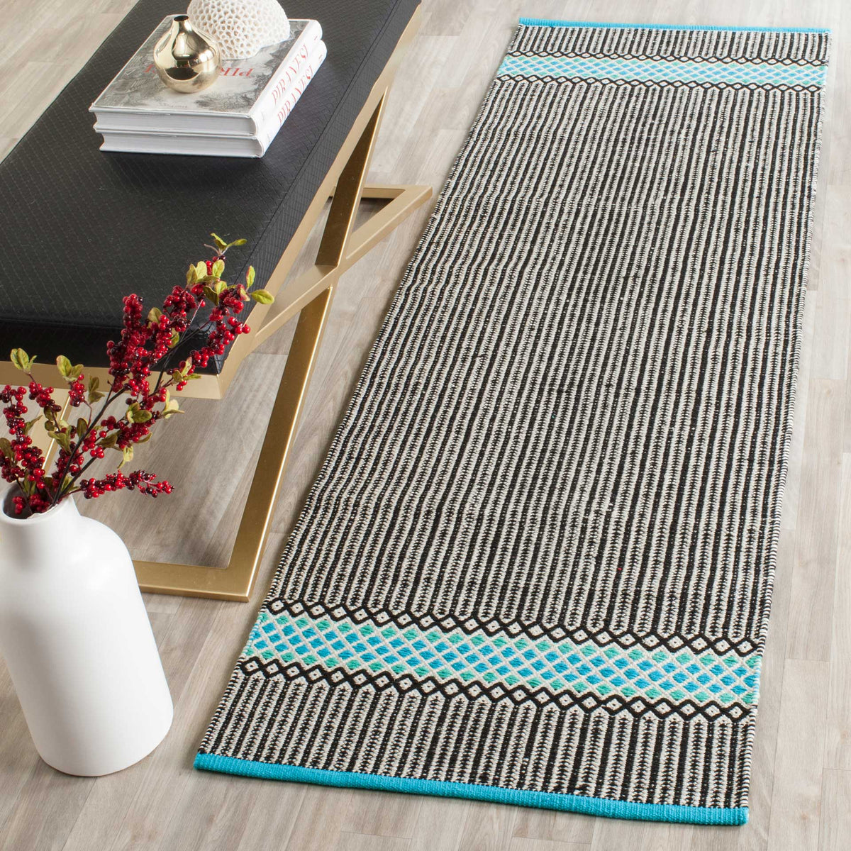 A slender runner brings turquoise diamond borders and crisp black-and-white stripes to a light wood floor.