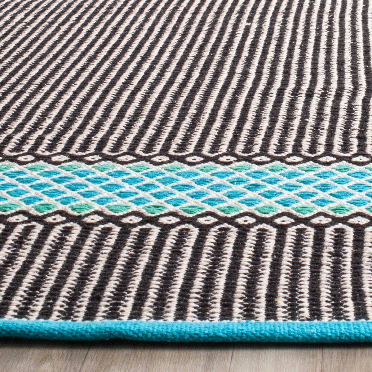 Turquoise latticework and a matching bound edge brighten the rug's textured striped weave
