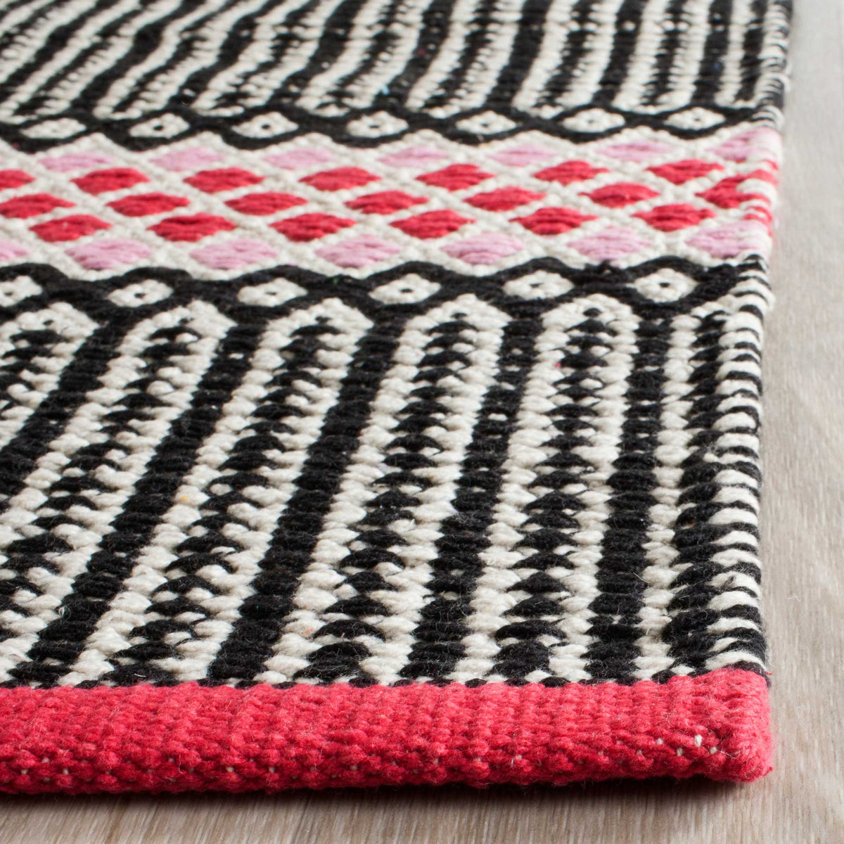 Textured black-and-white stripes meet a pink diamond band and a bright pink bound edge.