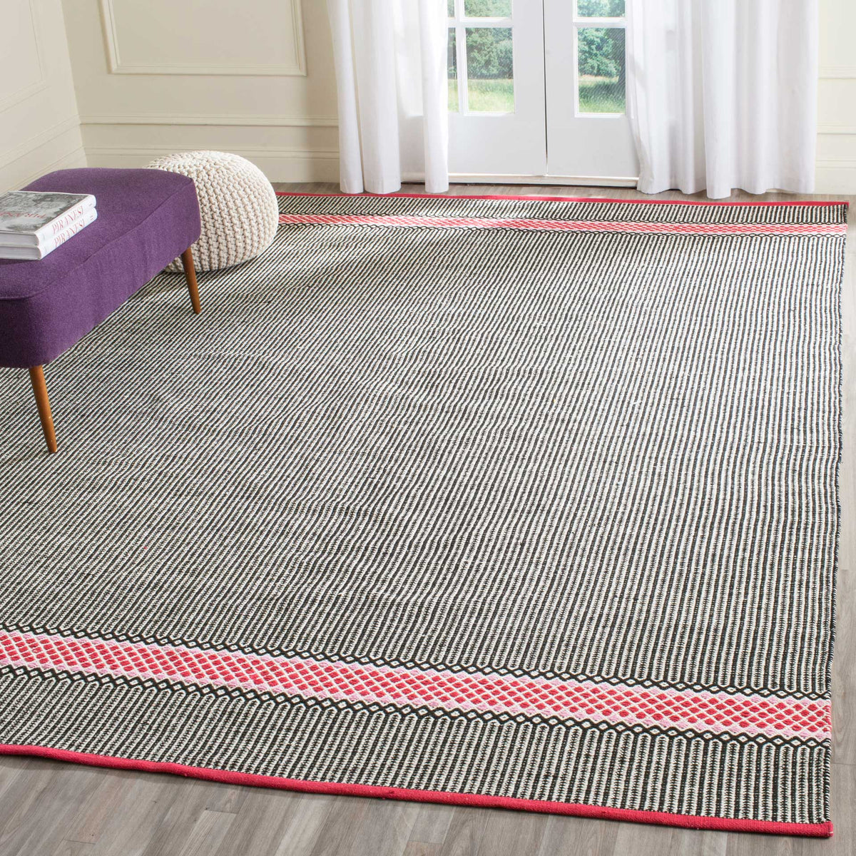 A broad striped field and vivid pink borders add color and texture to a light-filled living space