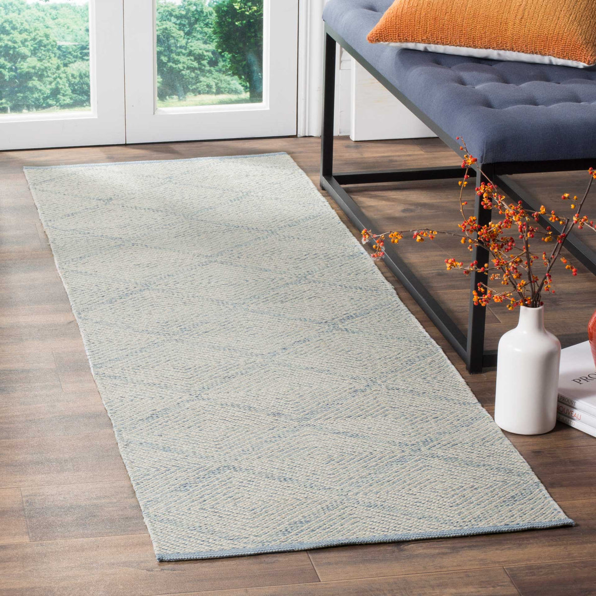 Pale blue diamond motifs lend a calm, airy touch alongside a tufted bench
