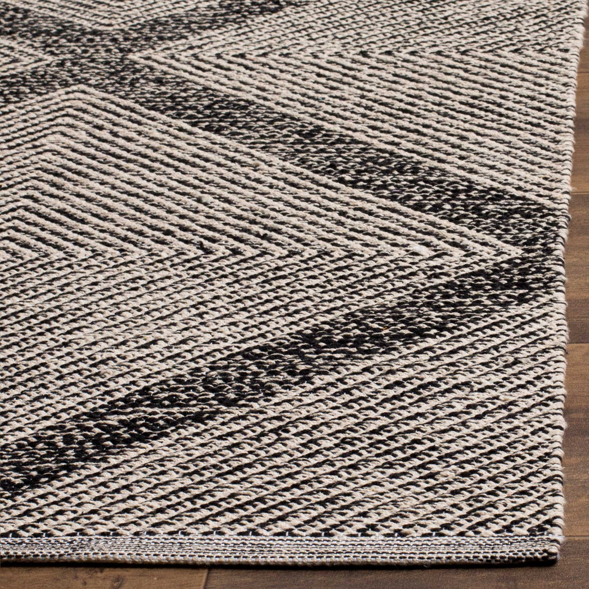 A neatly finished corner reveals the black and ivory cotton weave and bold diamond lines.