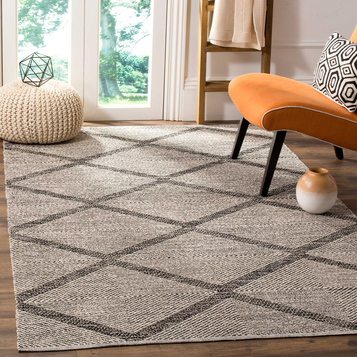 A black diamond trellis stands out across a light woven rug beneath modern furniture.