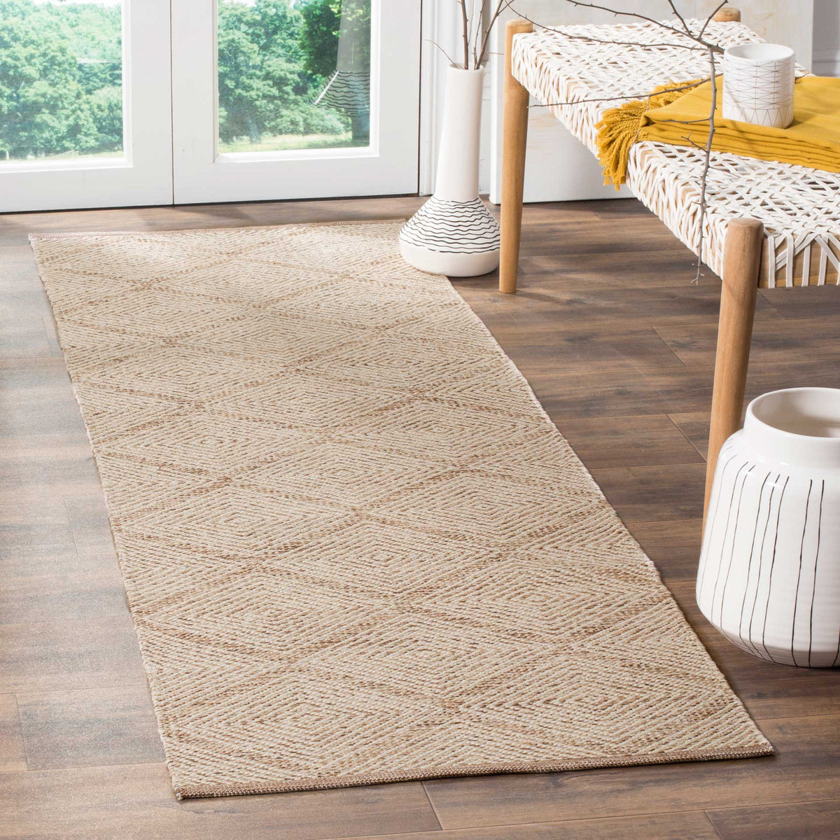 Warm beige diamonds add a relaxed, textured layer beside a woven bench