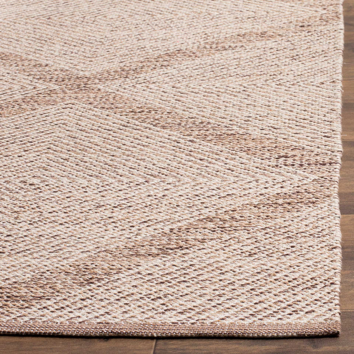A neatly bound corner frames the beige rug's textured diamond weave.