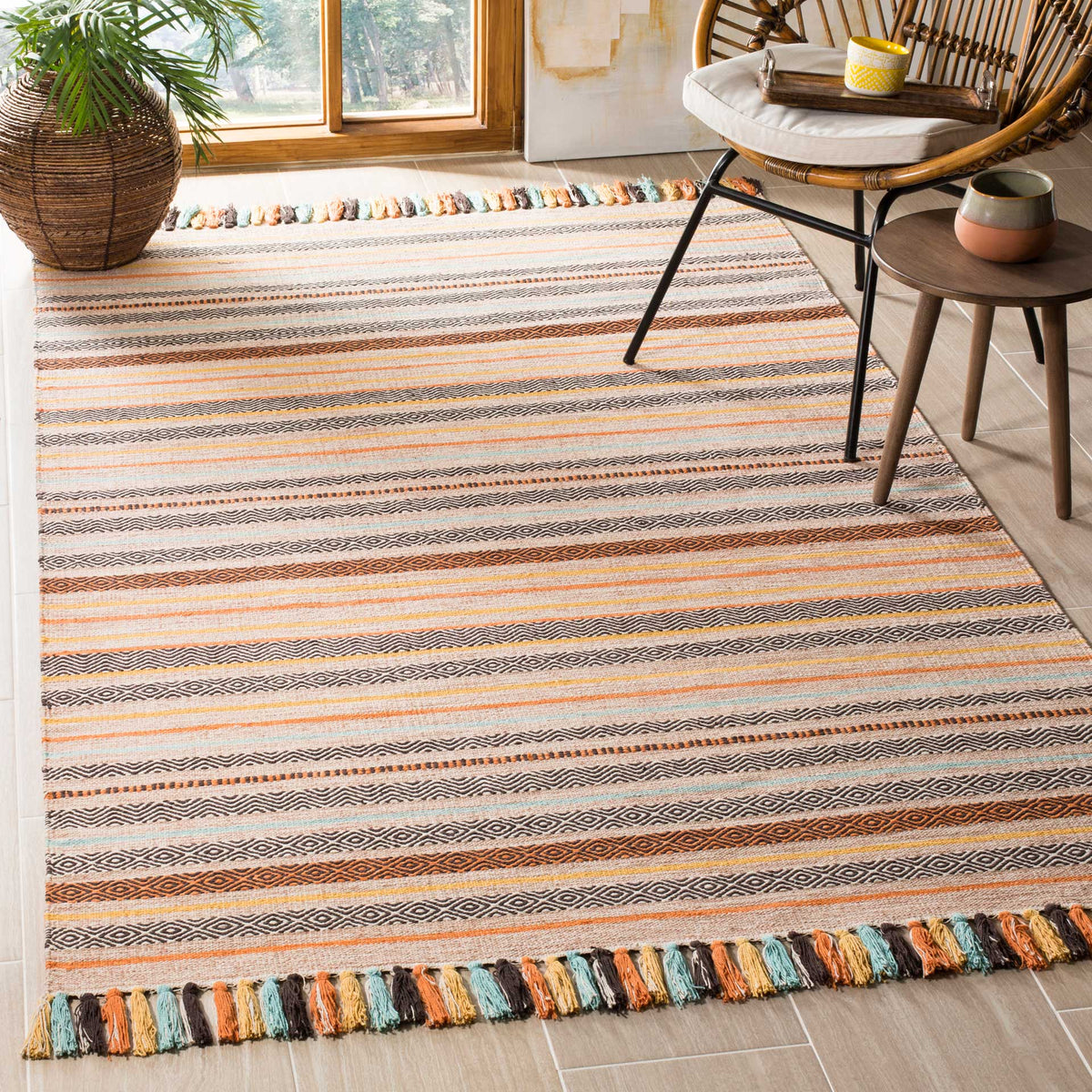 Warm beige and orange woven stripes bring color to a cotton rug finished with playful tassels.