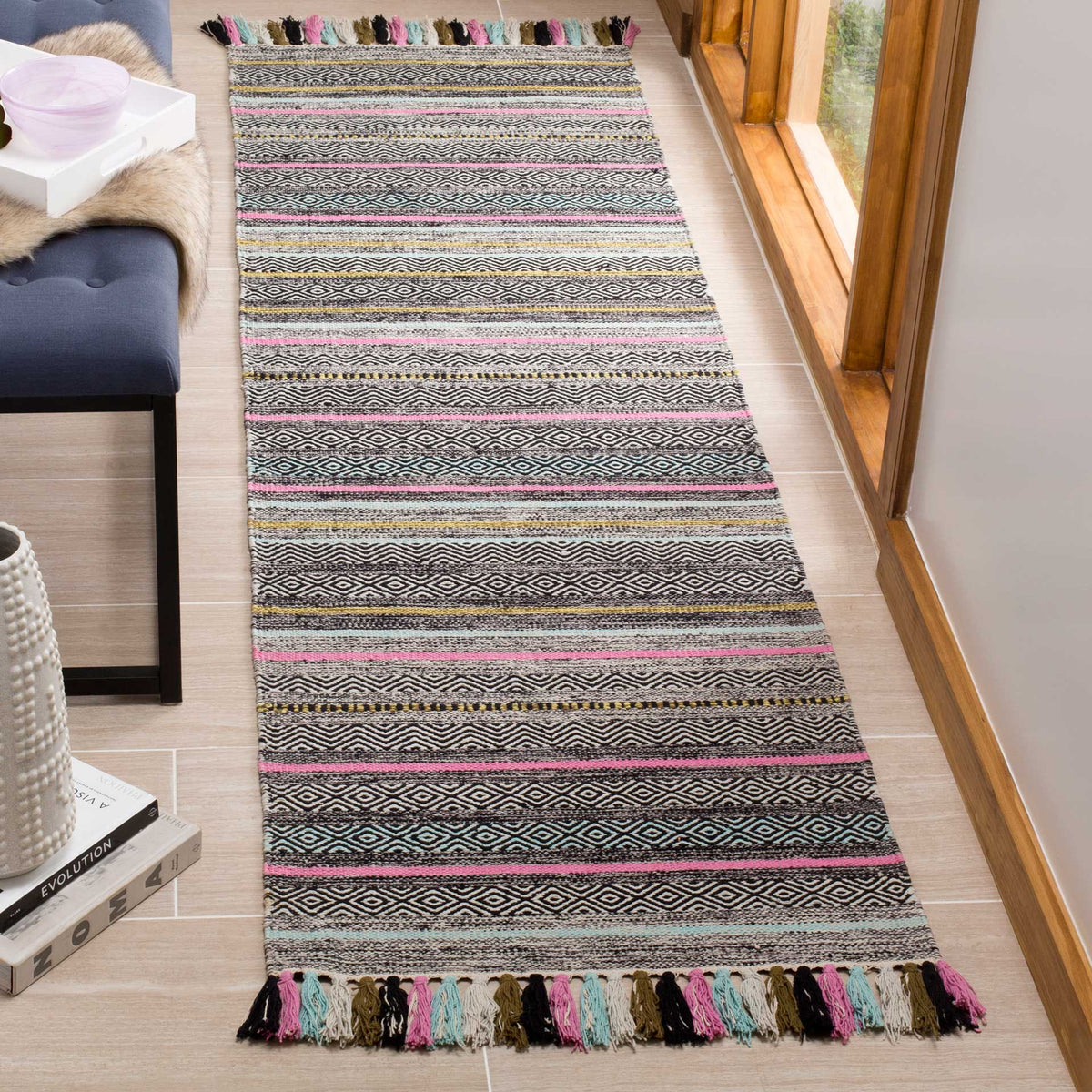 Fine black-and-ivory motifs meet pink and turquoise accents on a fringed runner