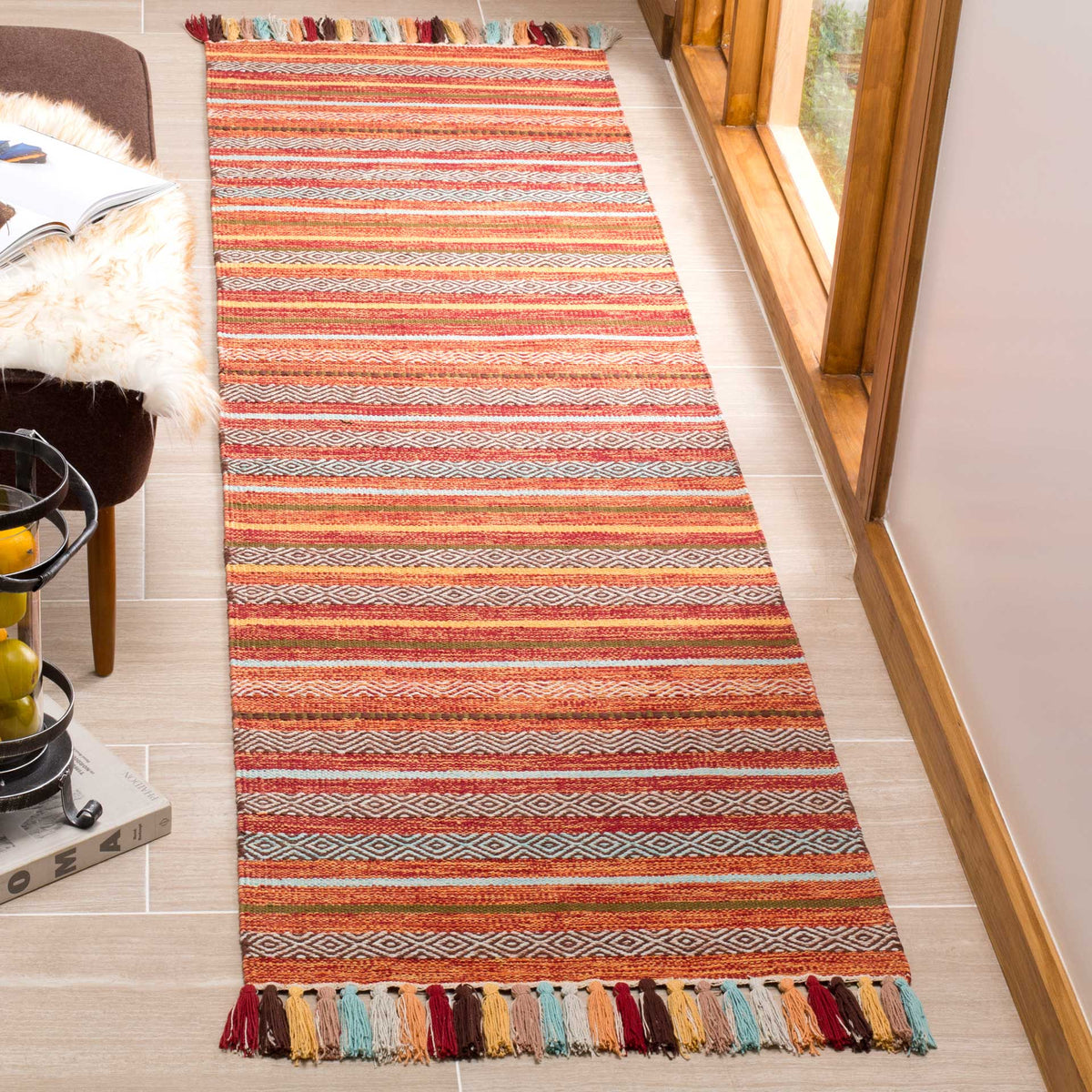Bold rust and burgundy bands are woven with fine geometric motifs and playful tassels