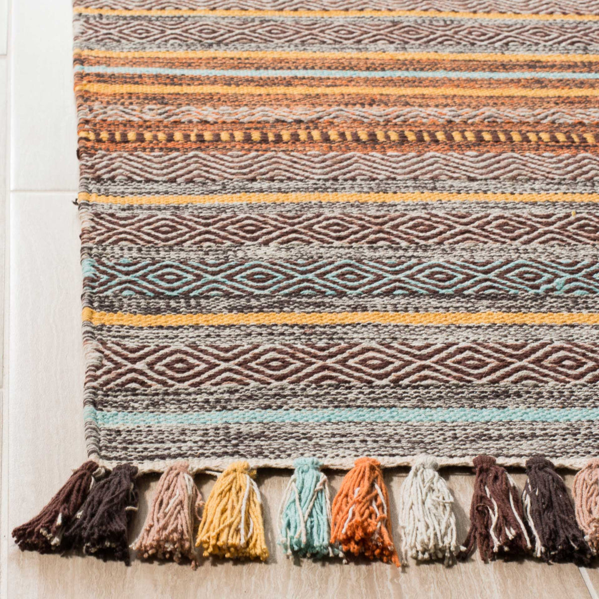 Textured brown diamonds meet turquoise stripes and tassels in orange, cream, and gold.