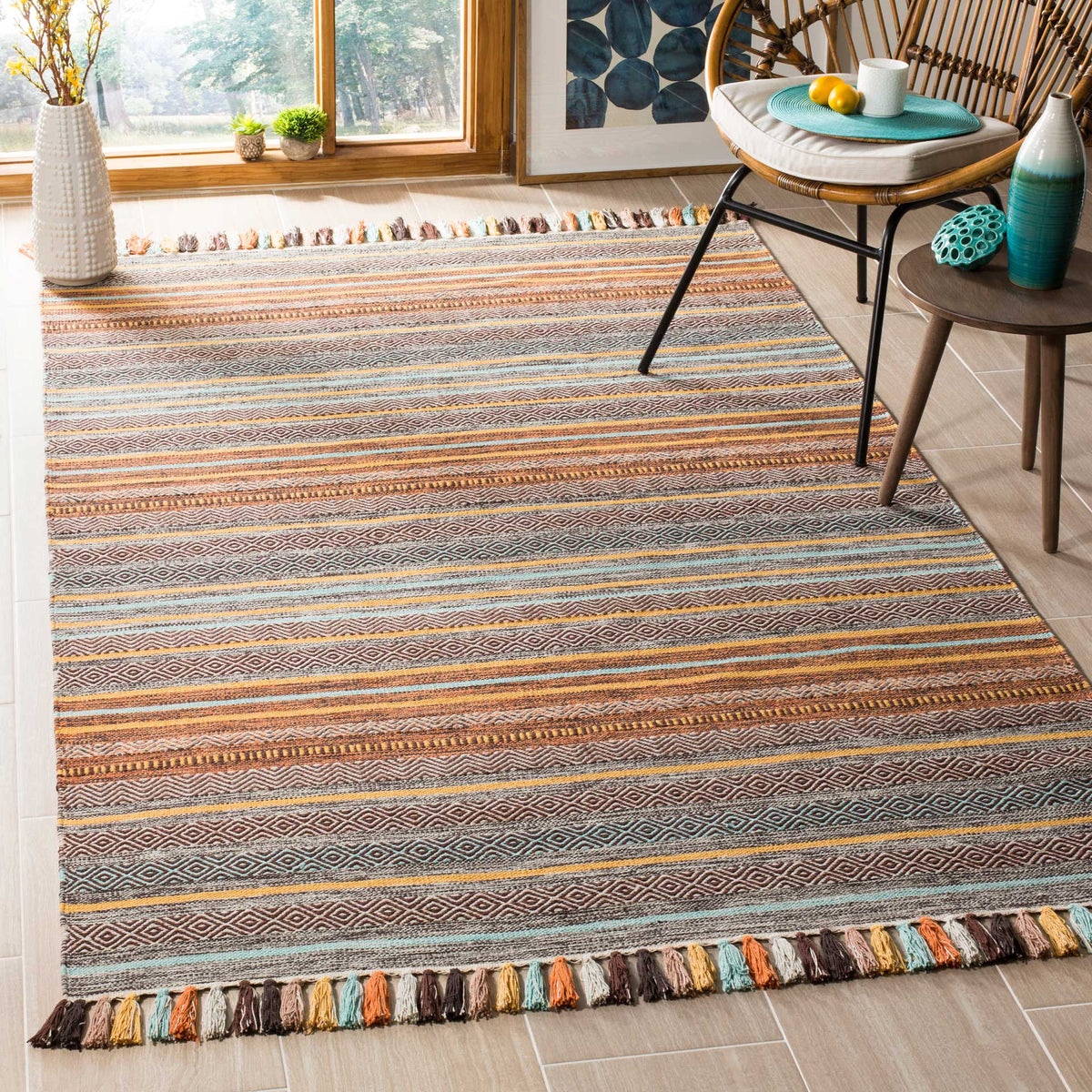Turquoise and brown geometric stripes lend character to a cotton rug with tasseled ends.