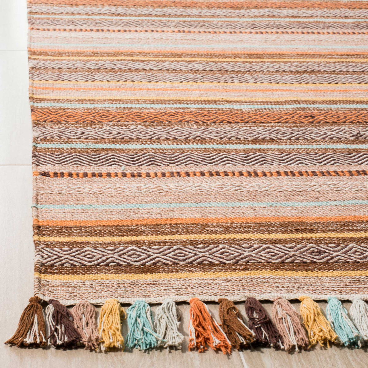 Brown and cream geometric weave softens with pale aqua lines and a colorful tassel border.