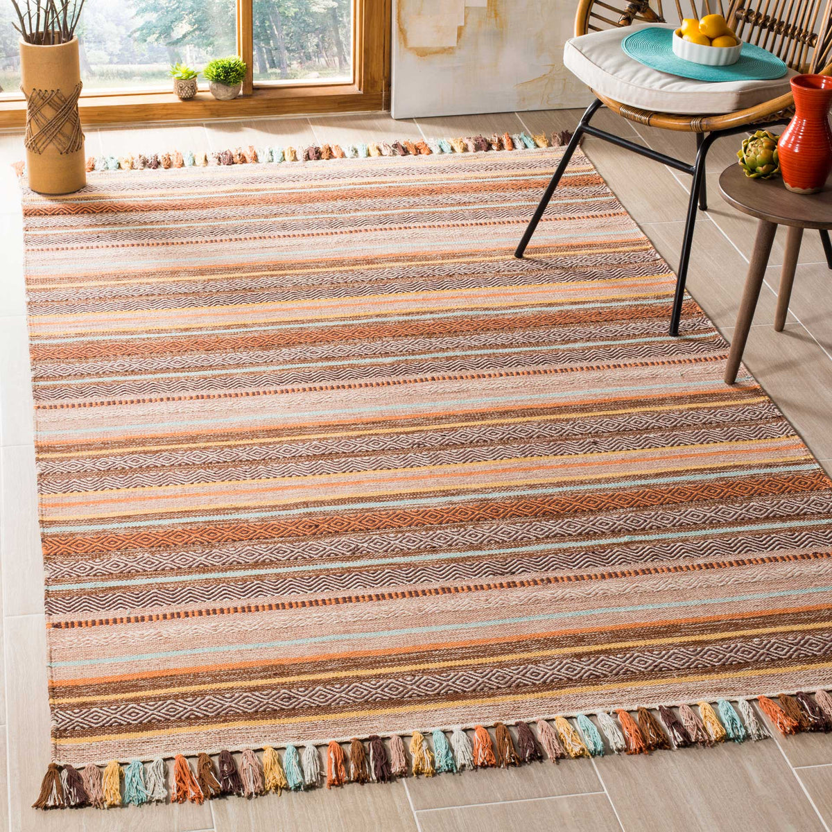 Earthy brown and rust stripes warm a cotton rug finished with lively multicolored tassels.