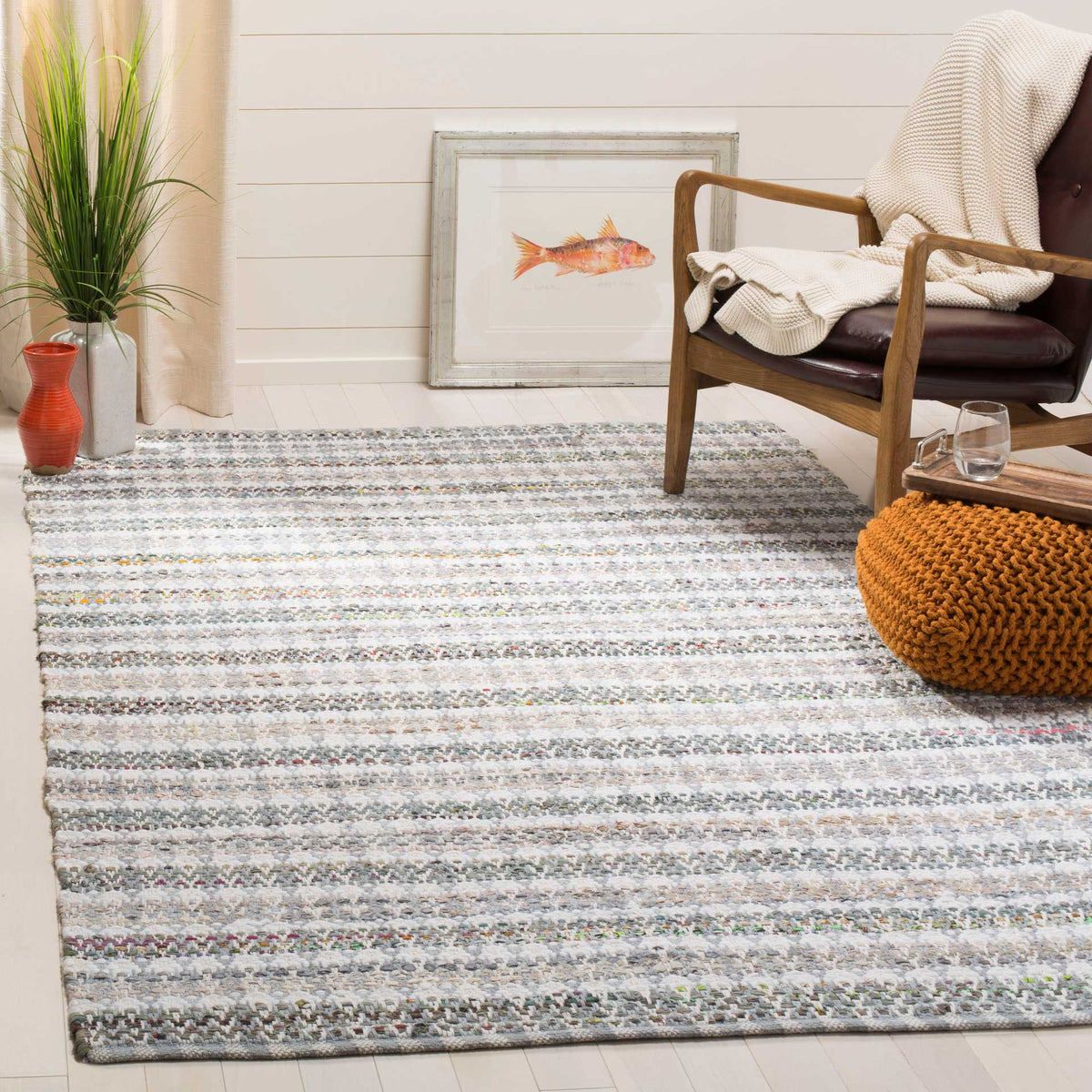 Soft gray striped cotton rug adds understated pattern beneath a cozy accent chair.