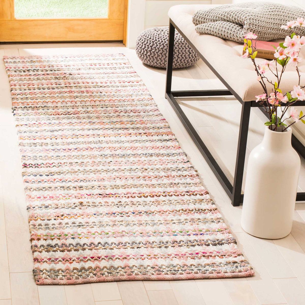 Soft pink and colorful stripes bring inviting texture to this entryway runner