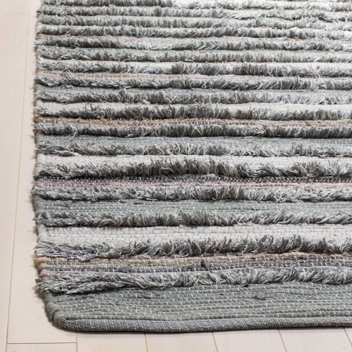 Raised gray yarns and fine pale stripes meet a tidy flatwoven edge for tactile contrast.