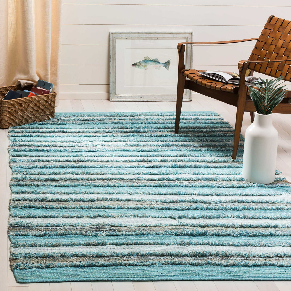 Aqua striped cotton rug adds soft texture and coastal color beneath a seating area.