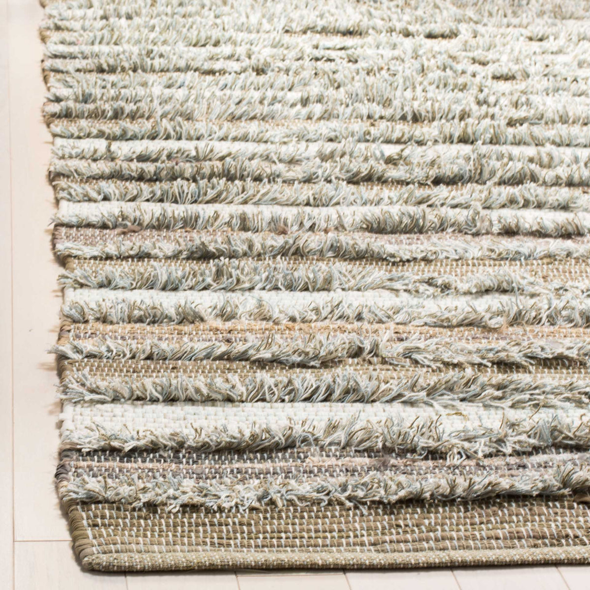 Textured beige and cream yarns form soft, raised stripes above a flatwoven edge.